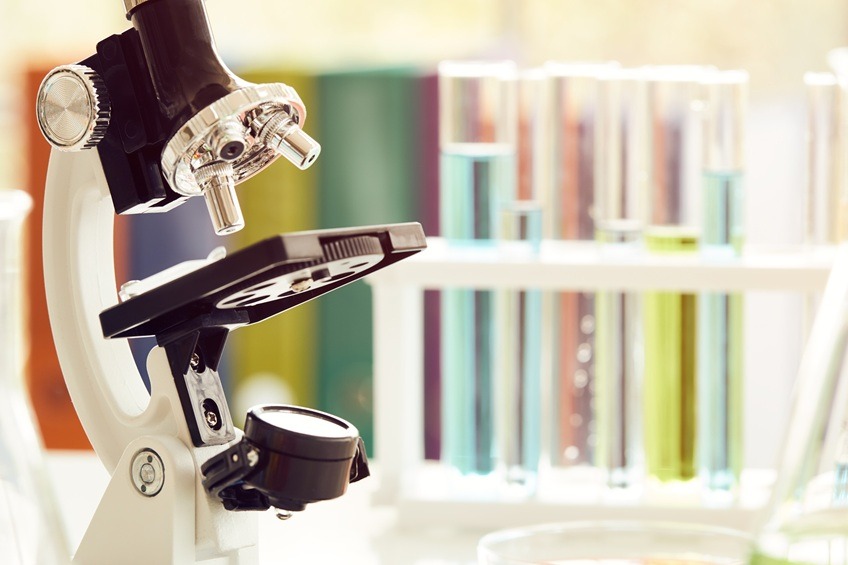Microscope on table with laboratory equipment in chemical lab; Science laboratory research and development concept
